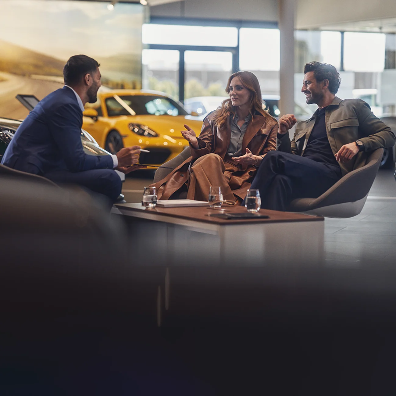 Ett par under en konsultation på Porsche Centre, olika Porsche-fordon i bakgrunden.