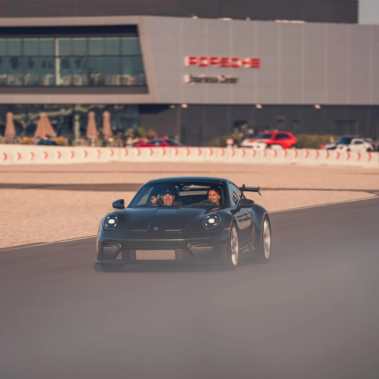 A Porsche racing model driving in a circuit.