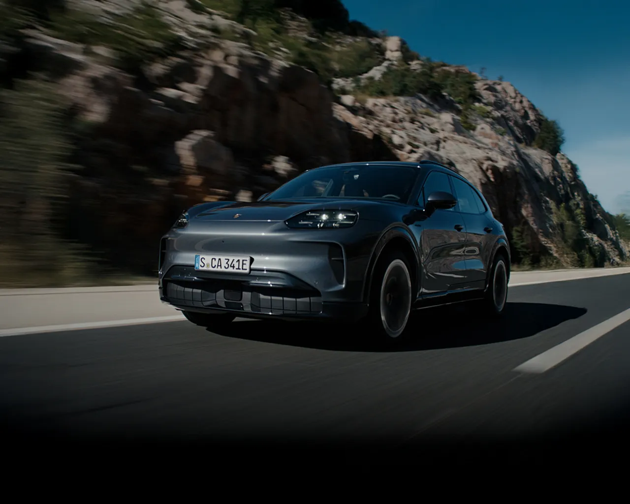 Porsche Cayenne jadące po otwartej drodze.