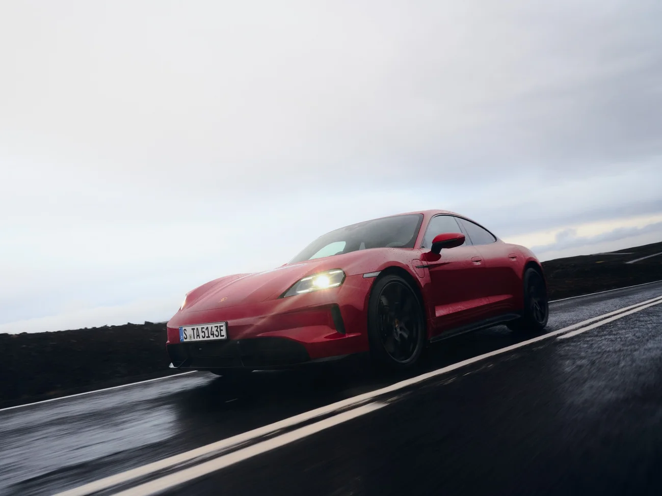 View of the front and side of the Porsche Taycan GTS in Carmine Red.