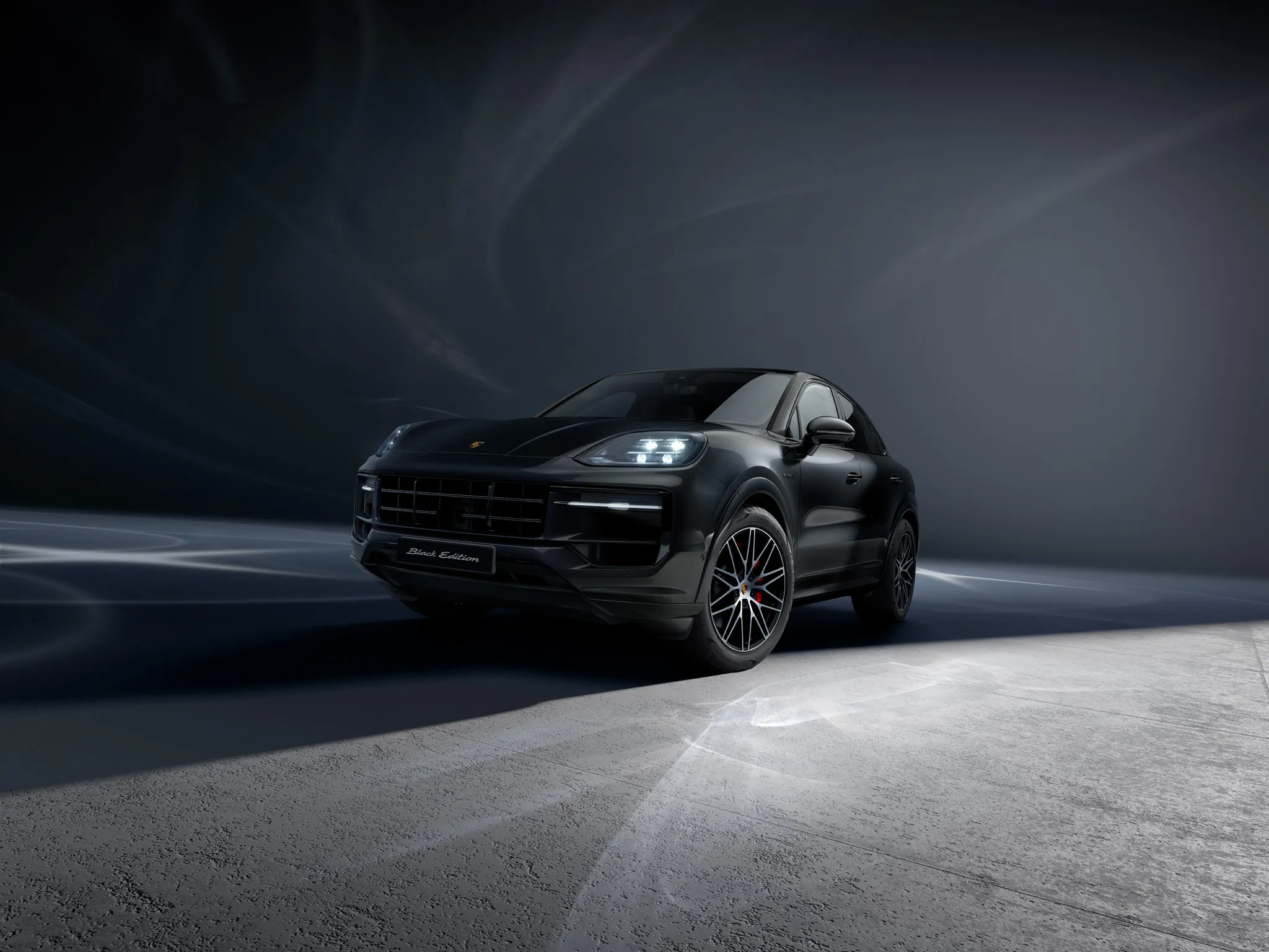 Shot of the back of a Cayenne S E-Hybrid Coupé Black Edition in a dark location