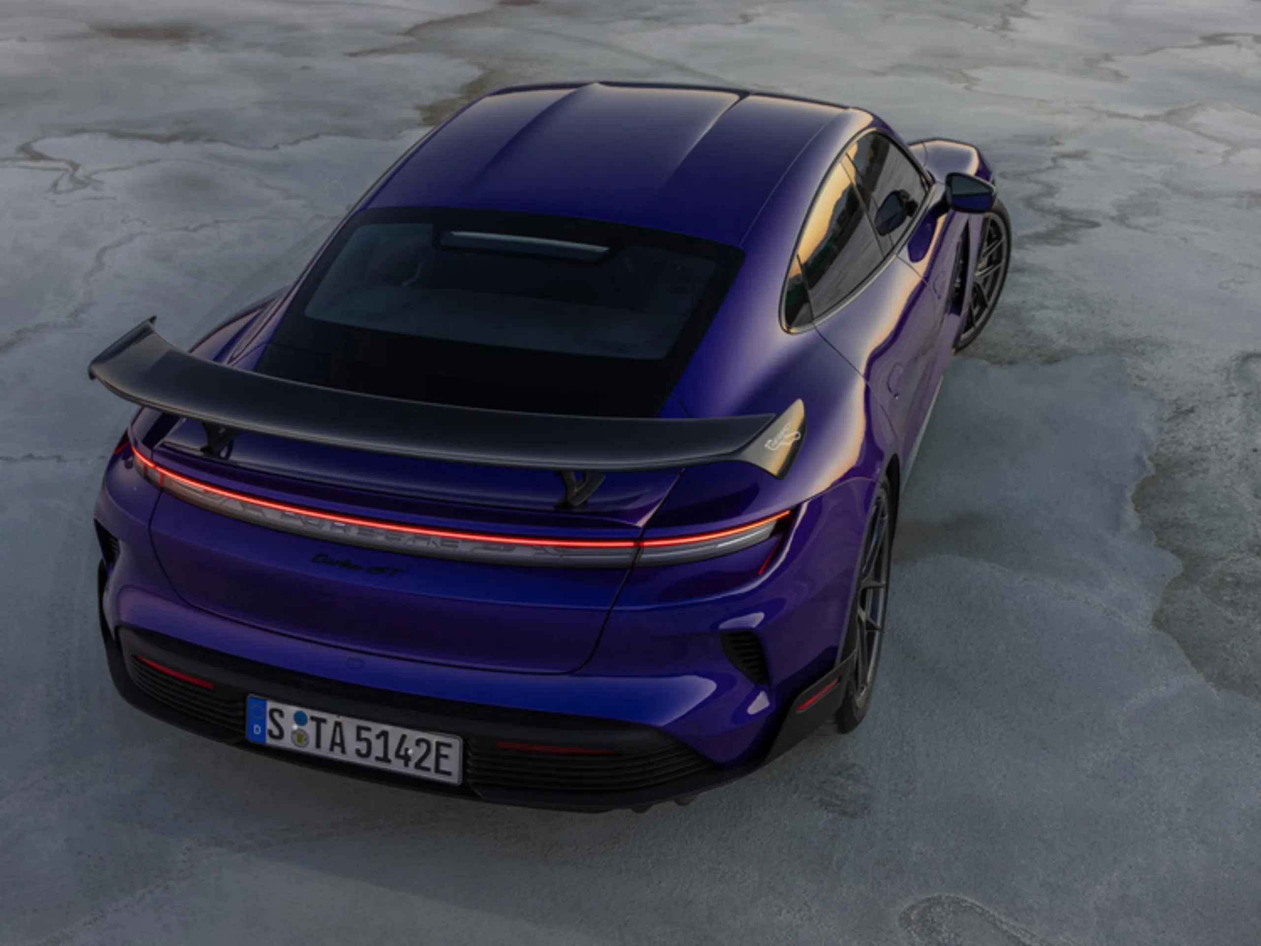 Rear shot of a Purplesky Metallic Taycan Turbo GT with Weissach package parked in a salt desert.