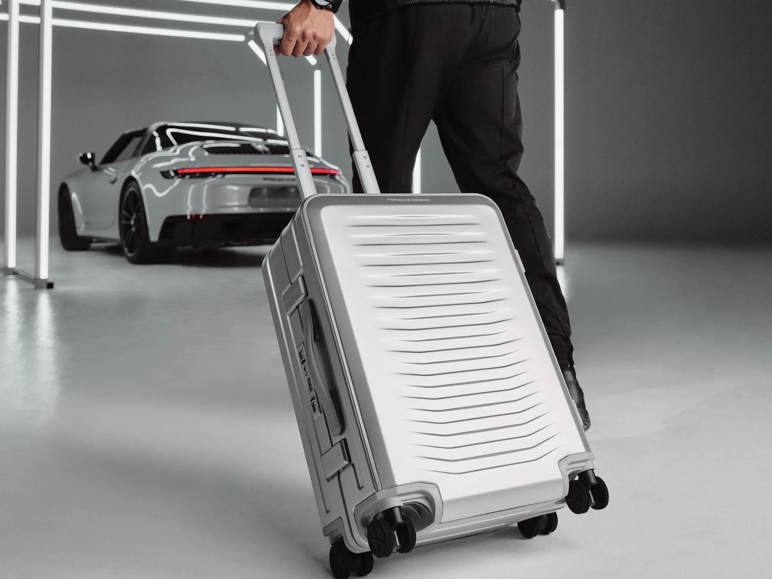 Homem puxa trolley de viagem em direção a um 911.