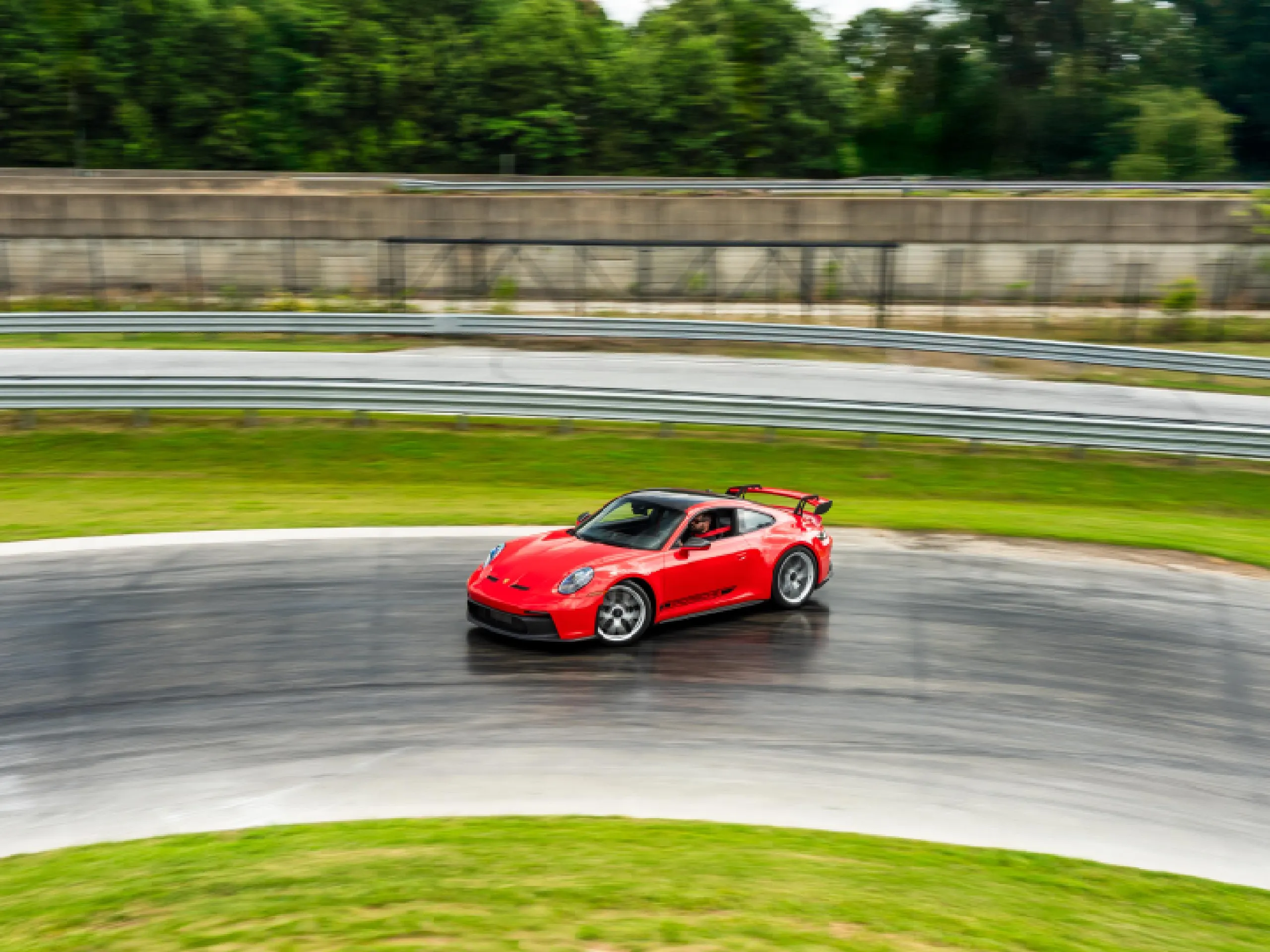 A red 911 GT3 seen drifting around a corner on the Porsche Experience Center track.