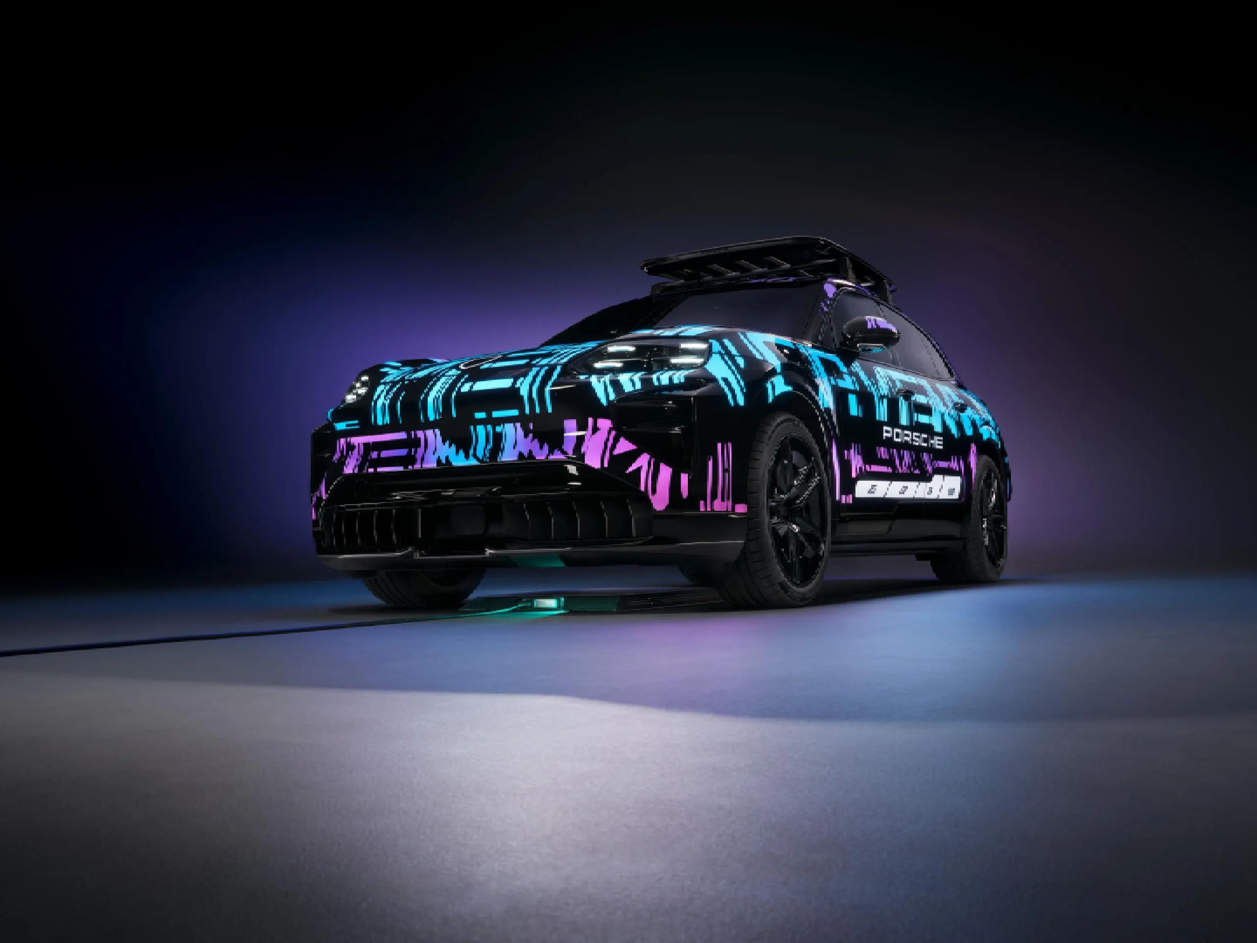 Side shot of a Cayenne Electric with blue and purple lights in a dark location.