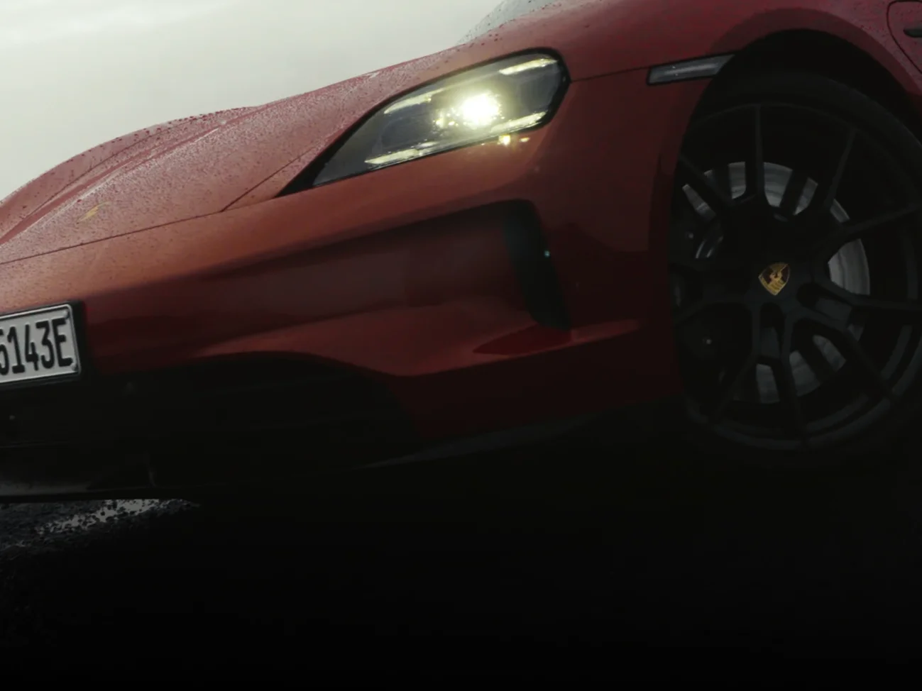 View of the front and side of the Porsche Taycan GTS in Carmine Red.