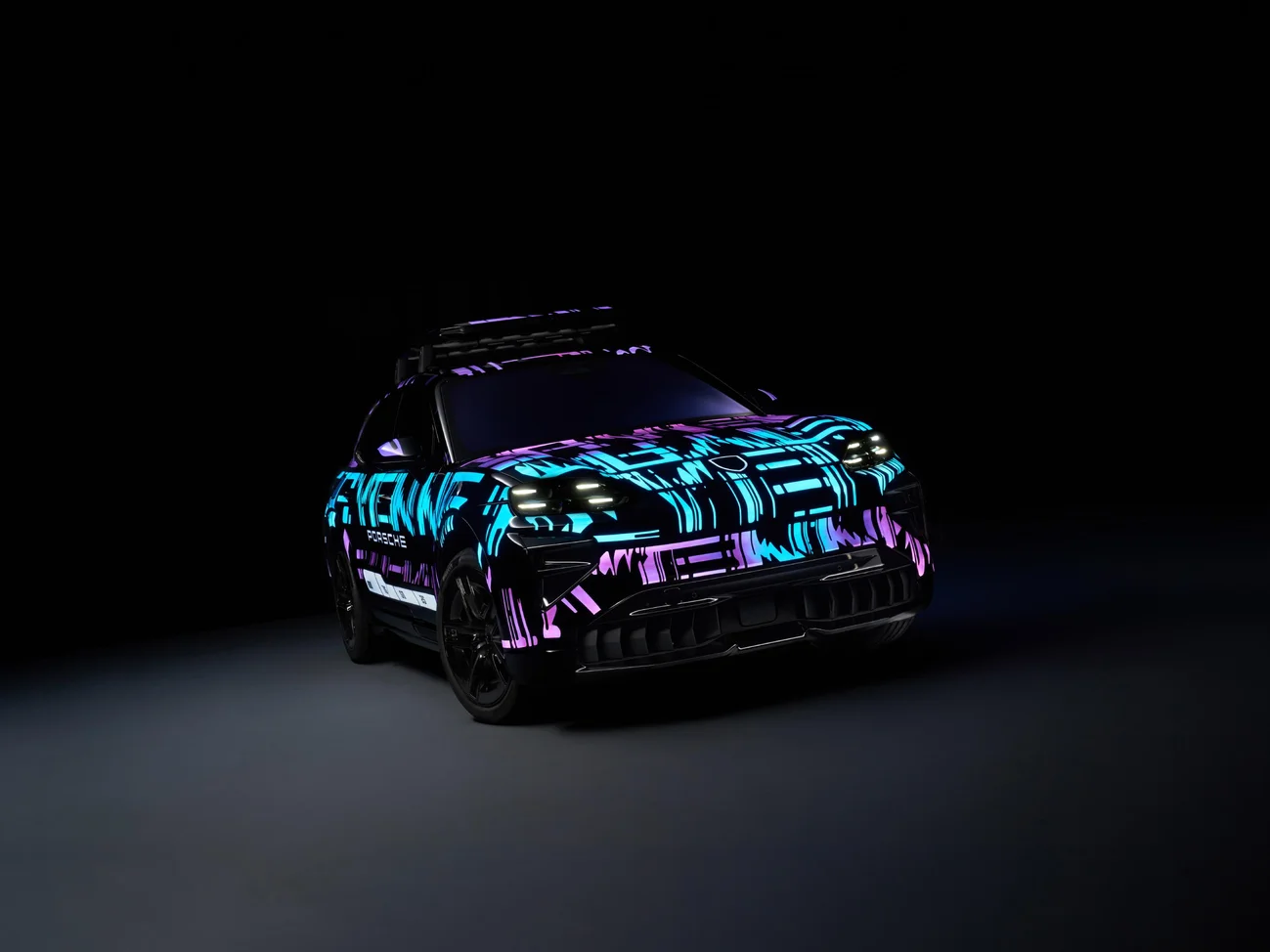 Side shot of a Cayenne Electric with blue and purple lights in a dark location.