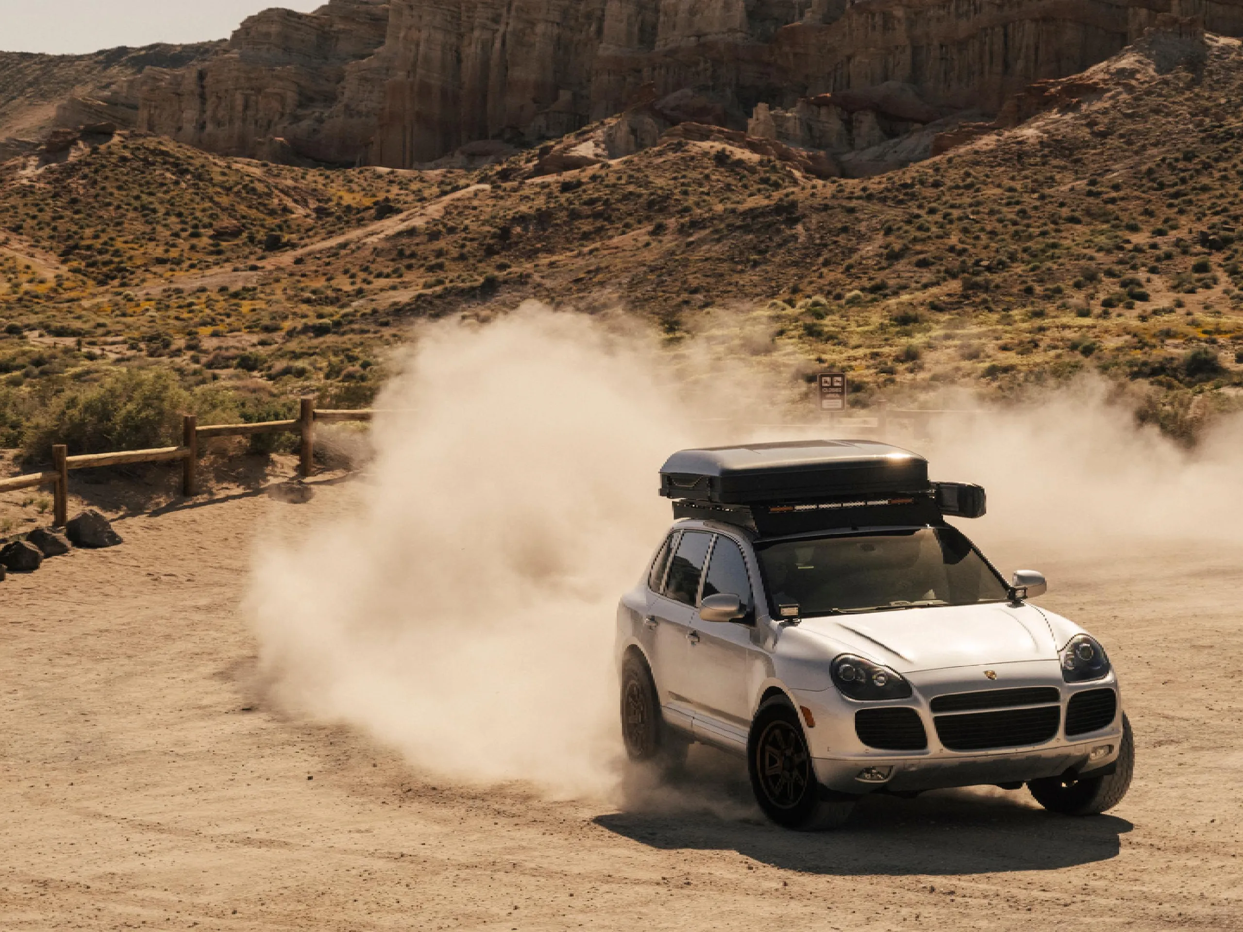 Un Cayenne siendo conducido por el desierto y dejando un rastro de arena.