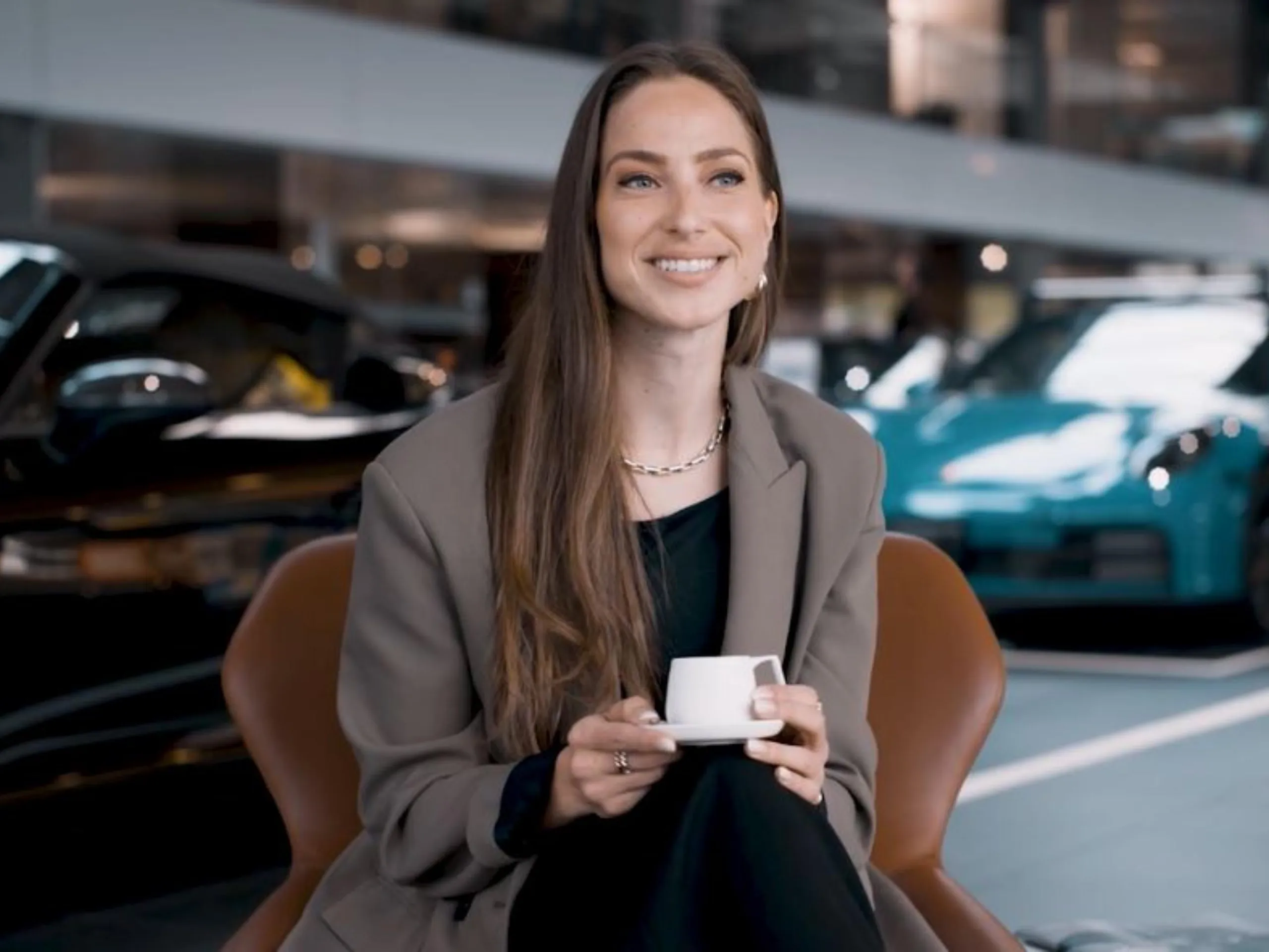 A woman sitting at a Porsche Center