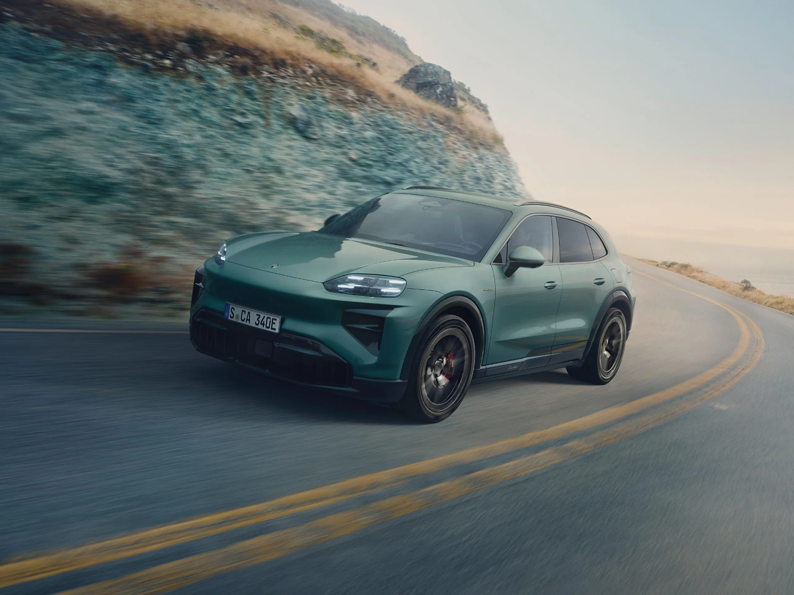 La nouvelle Porsche Cayenne avec des lumineux en bleu et violet, présentée dans un studio sombre.
