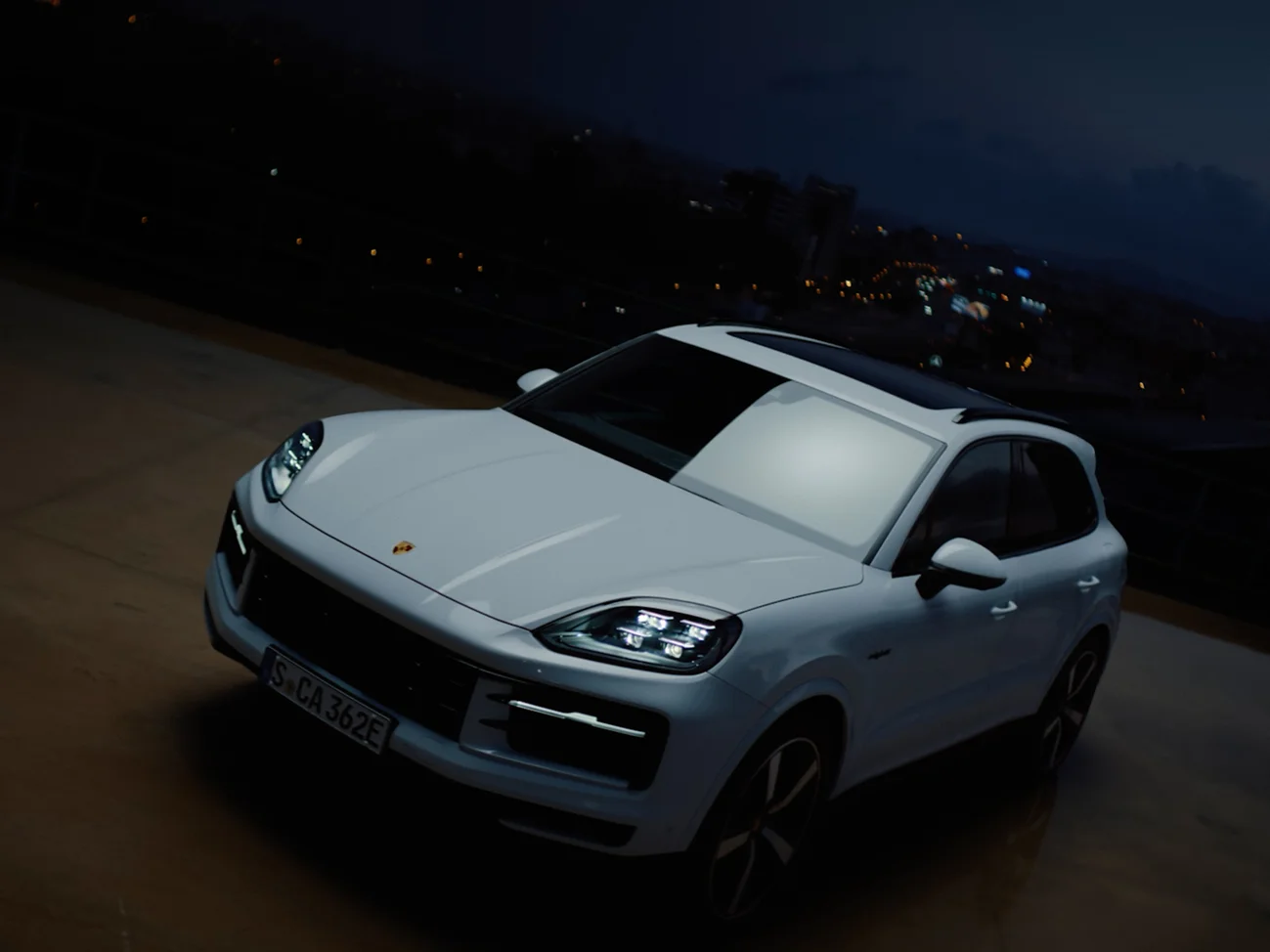 A Cayenne S E-Hybrid on a plateau in front of the skyline.