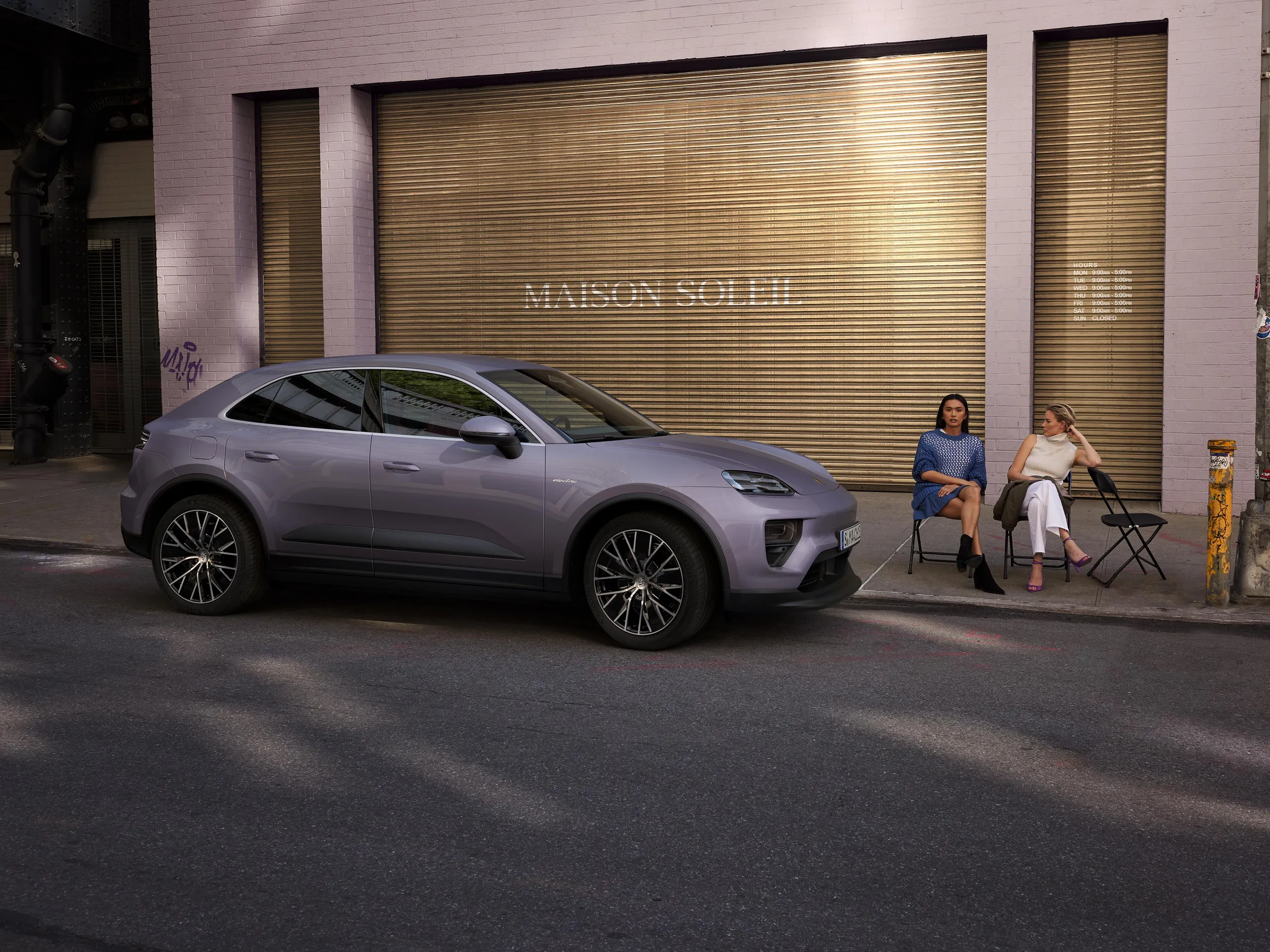 A provence Macan 4 parked on a street in front of a boutique.