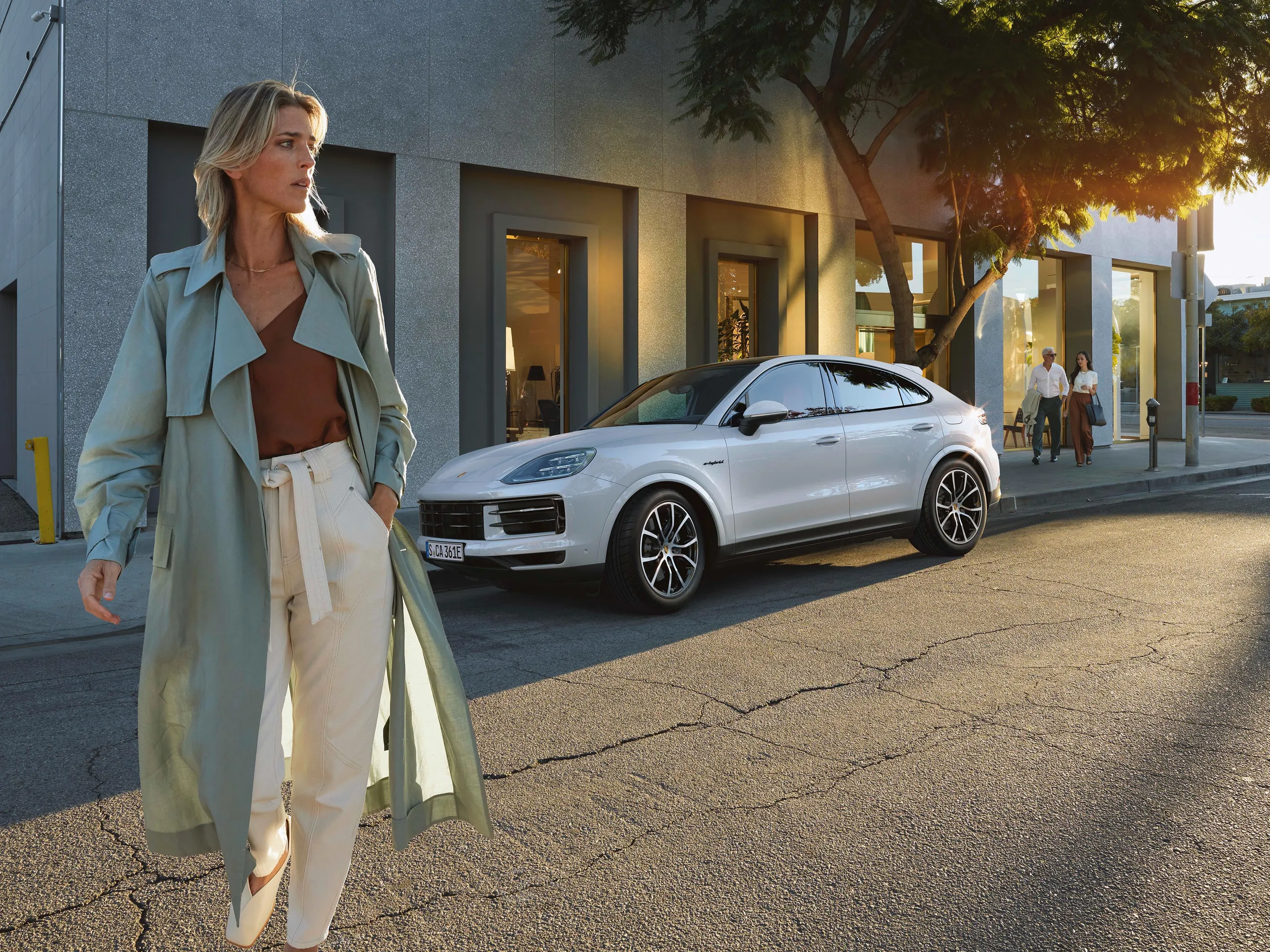 White E3 II E-Hybrid Coupé standing at the side of the road in front of a shop and a woman walking through the picture