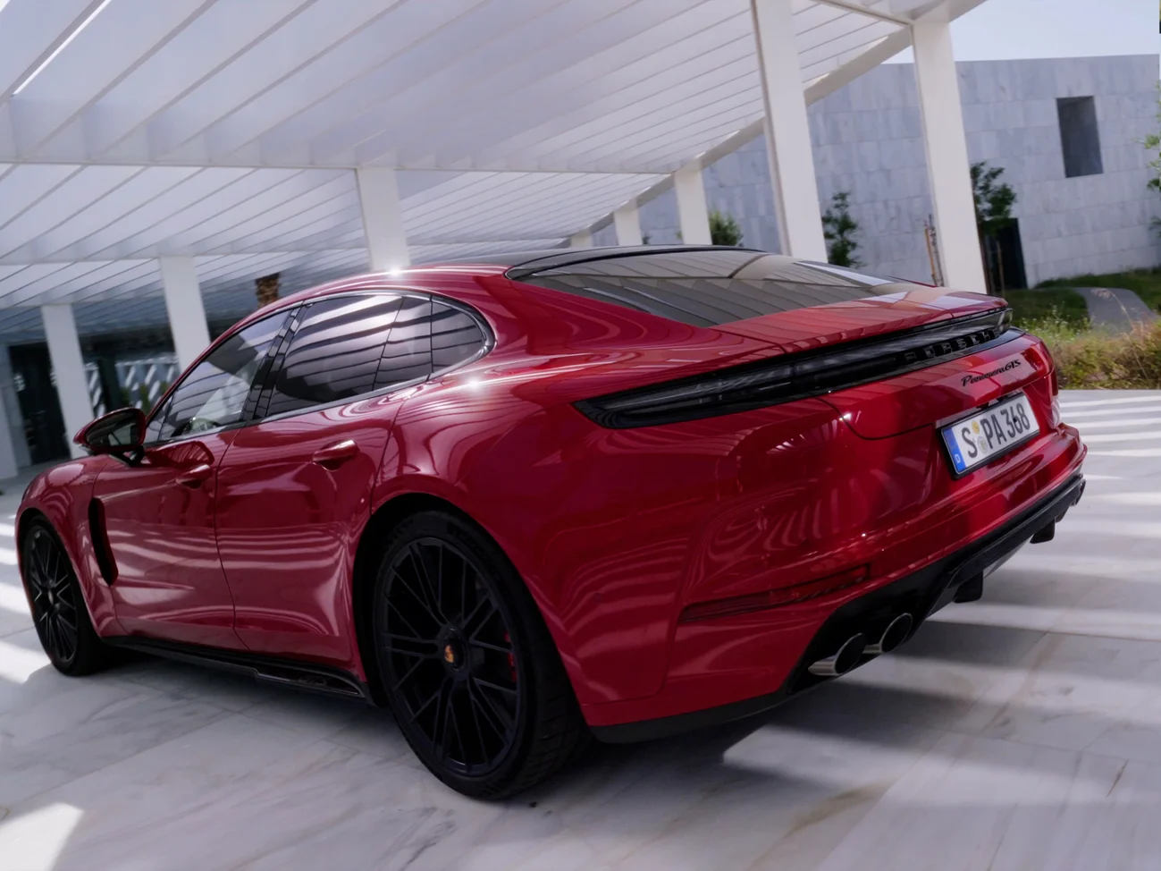 Porsche Panamera GTS in Carmine Red View from behind of the rear with darkened tail light strip
