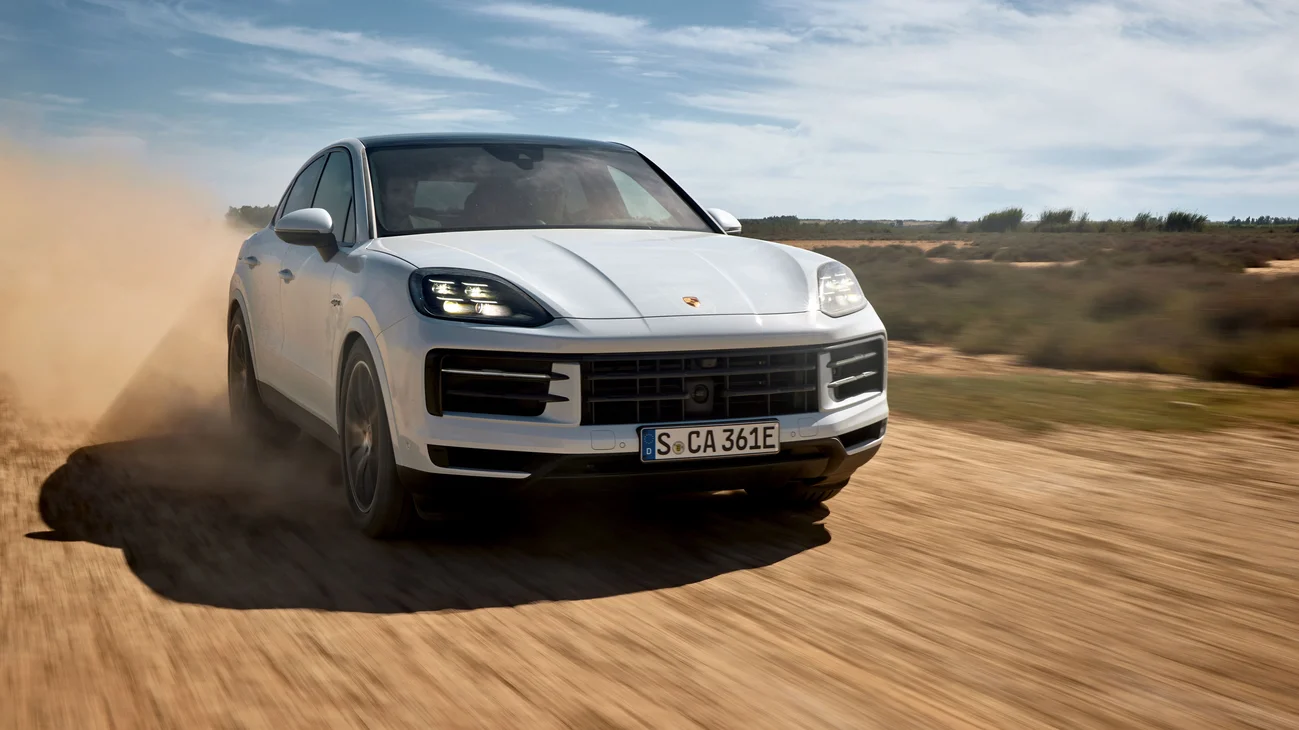 Several dynamic shots of a Cayenne E-Hybrid Coupé driving on a road.
