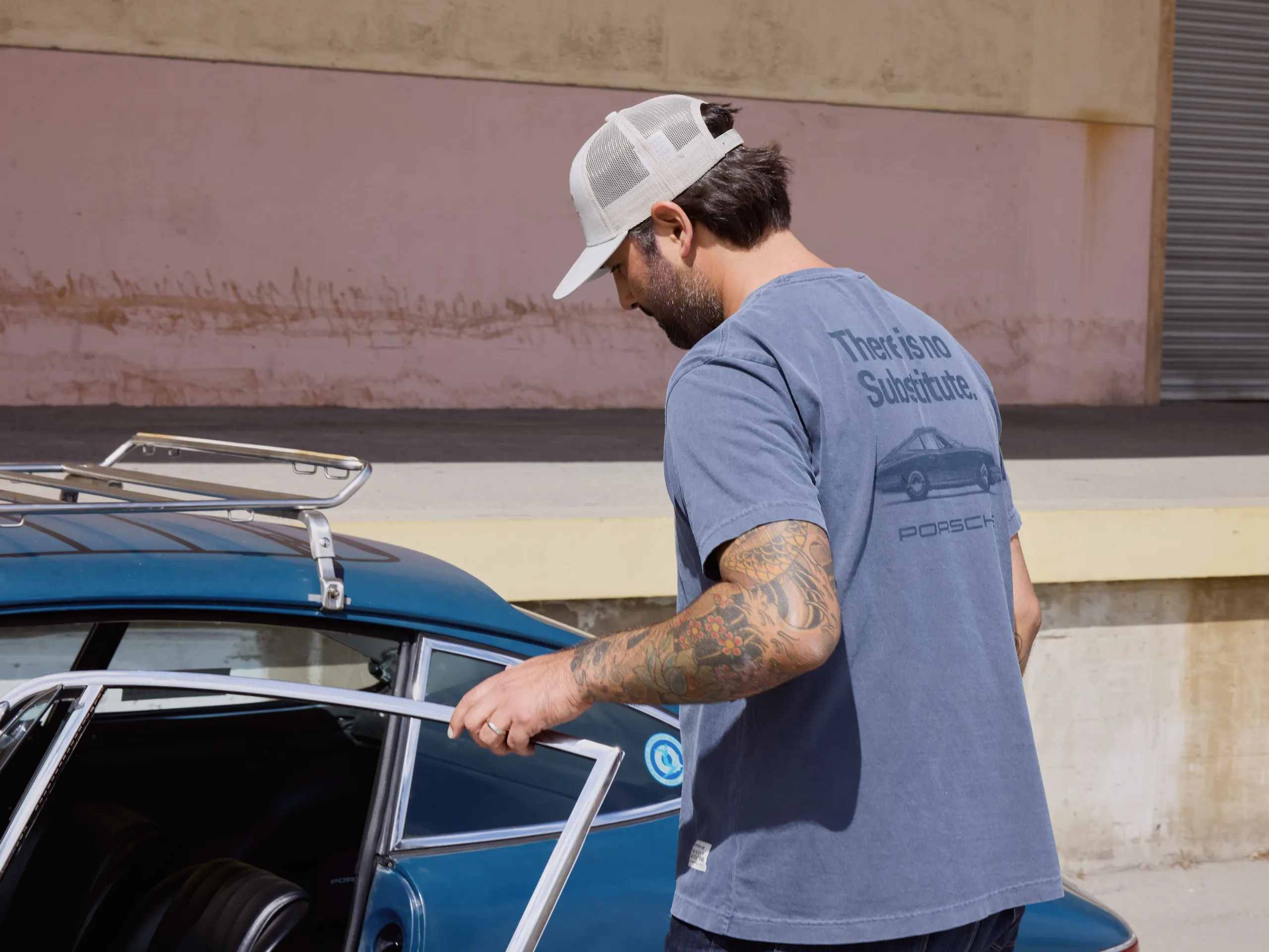 Man wearing There is No Substitute Collection entering a Porsche.