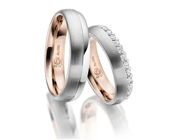 Ein Paar eleganter Eheringe, einer mit glatter Oberfläche und der andere mit kleinen Diamanten verziert, beide mit Roségold-Innenseite.