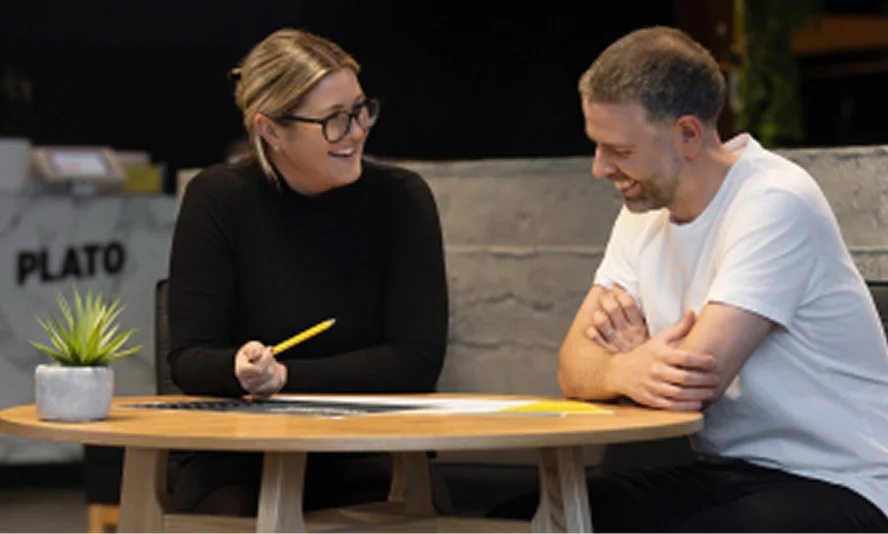 Two Plato team members collaborating at a table in the studio