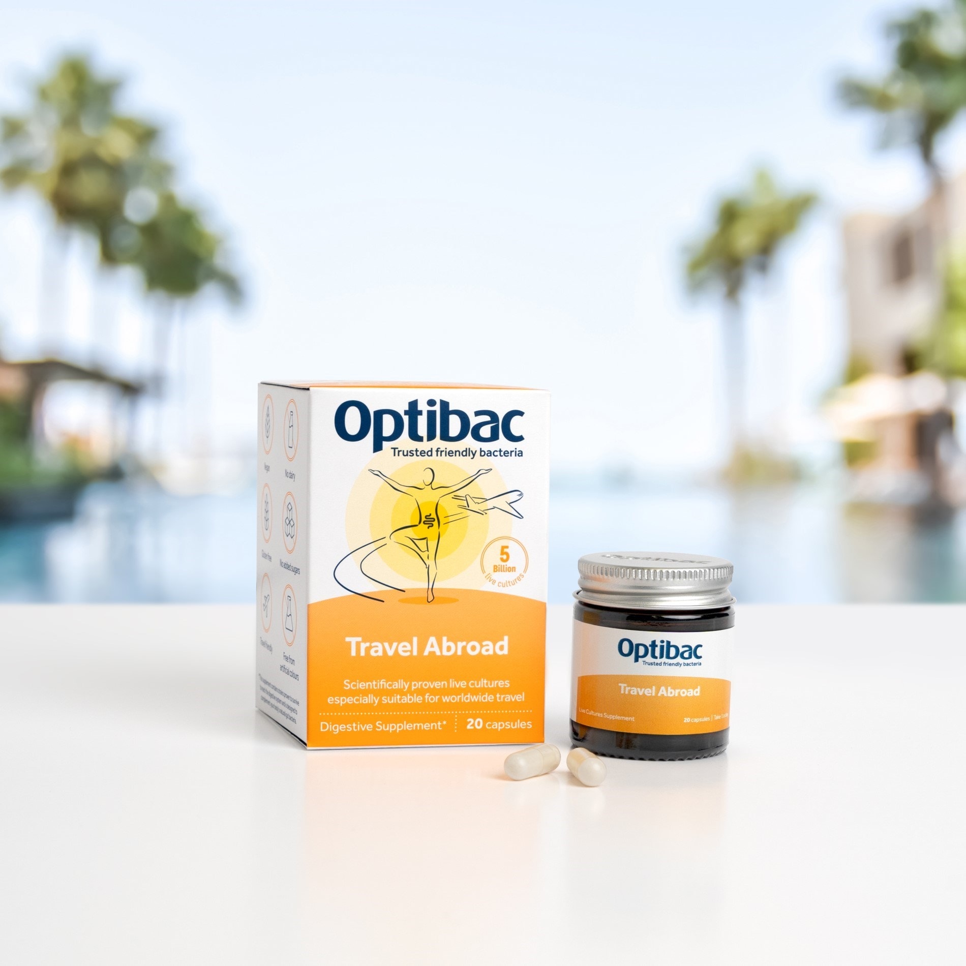 Optibac Travel Abroad probiotic box and jar with capsules, set against a blurred outdoor poolside background.