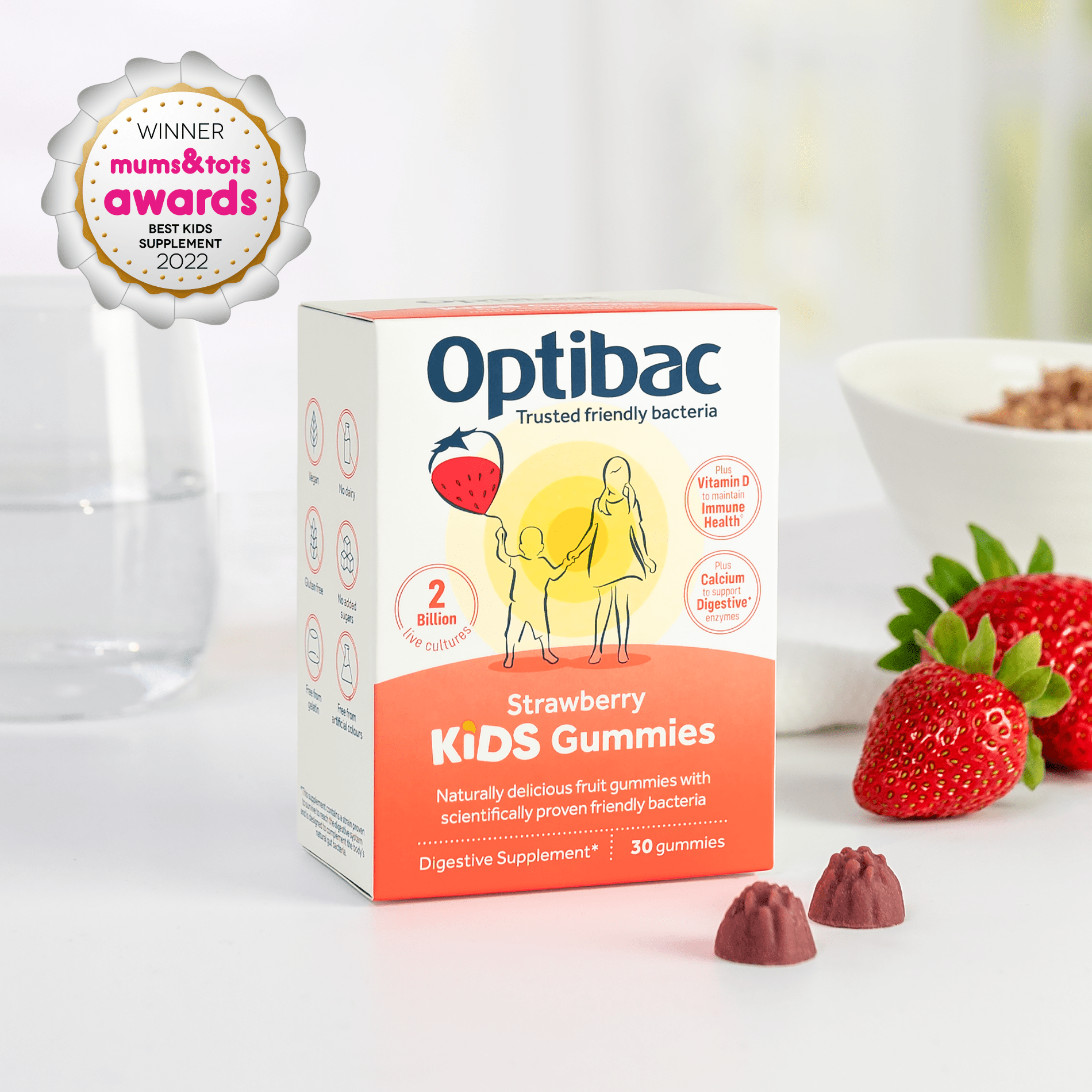 Box of Optibac Kids Gummies on a table with strawberries and a bowl; awarded "Best Kids Supplement 2022" by Mums & Tots.