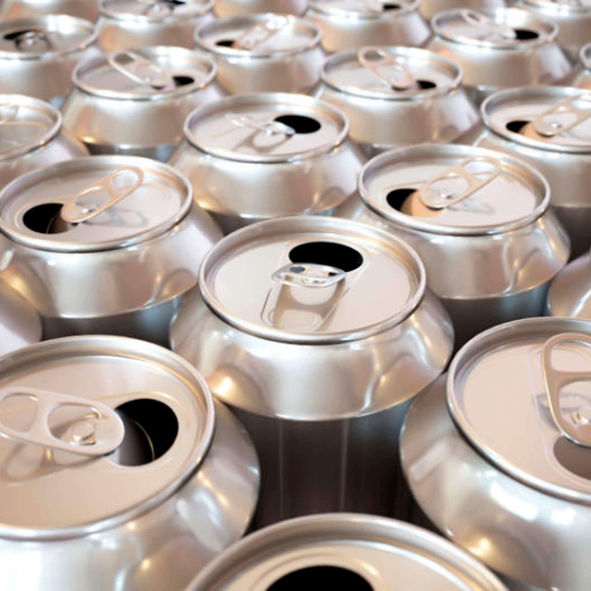 Close-up of numerous silver aluminum cans with open pull tabs, arranged closely together, creating a uniform and reflective surface pattern.
