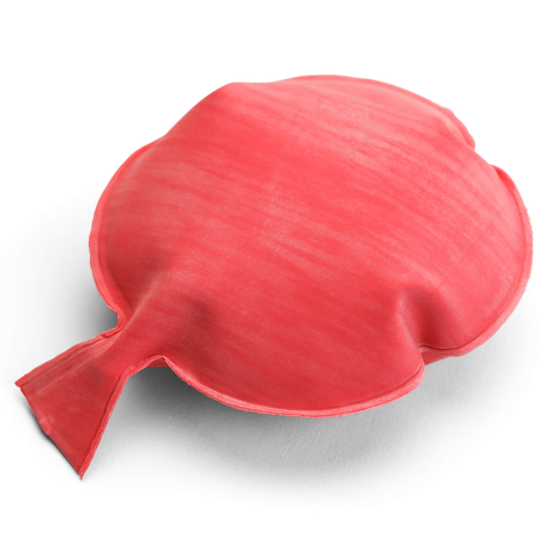 A red whoopee cushion with a nozzle, placed on a white surface.