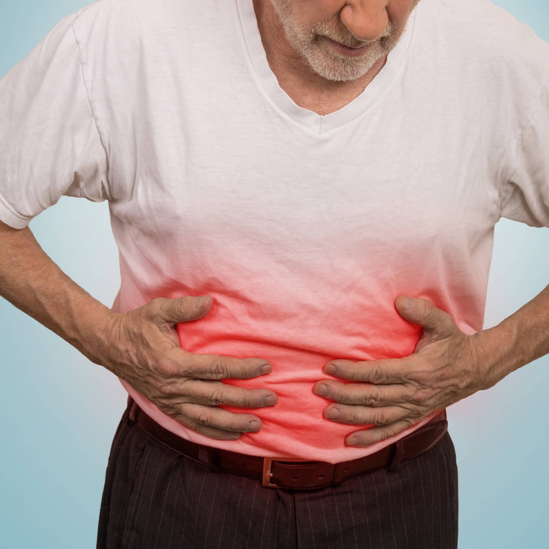 Elderly man clutching his stomach, wearing a white shirt with a red gradient effect, indicating abdominal pain against a light blue background.