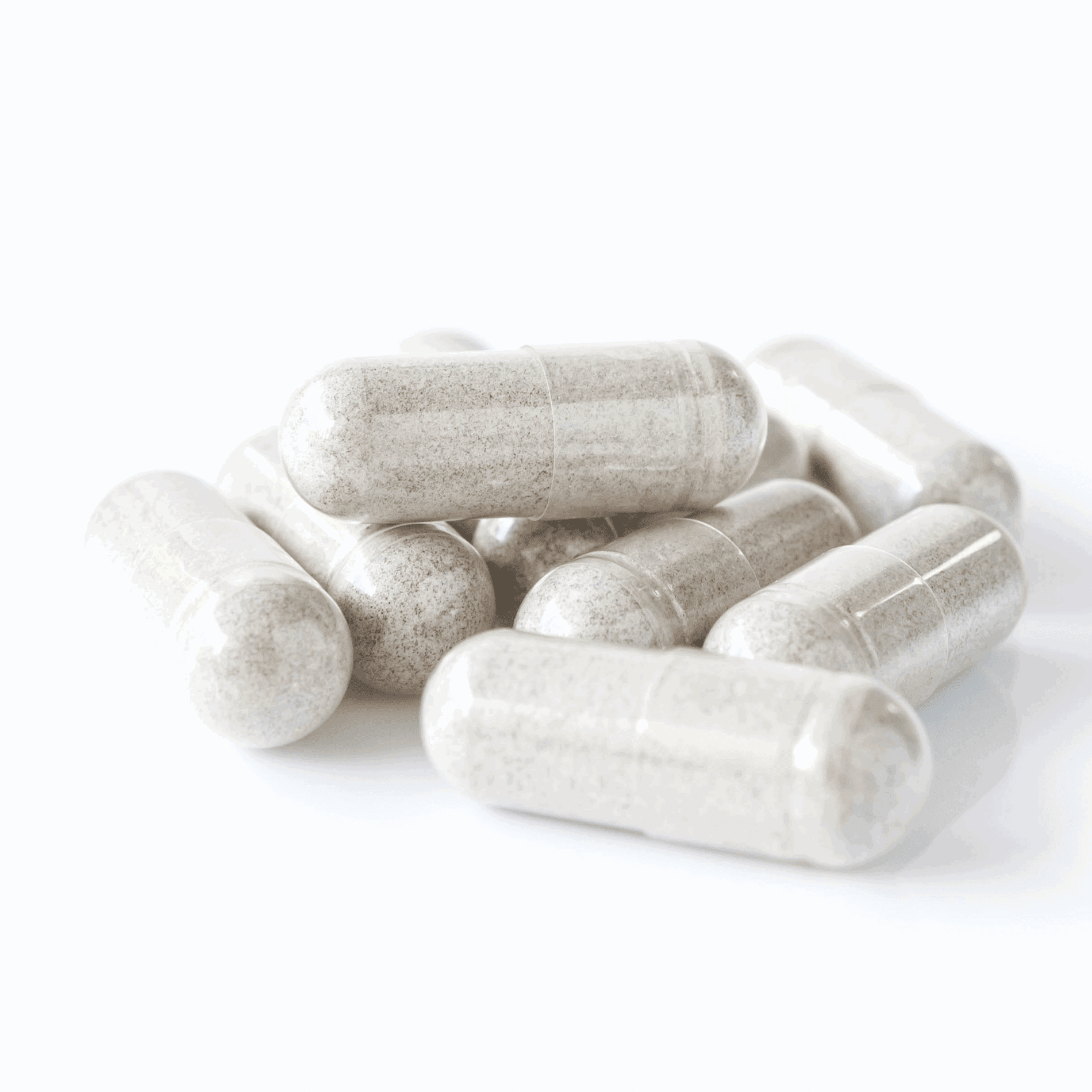 A pile of translucent capsules filled with a light gray powder, set against a plain white background.