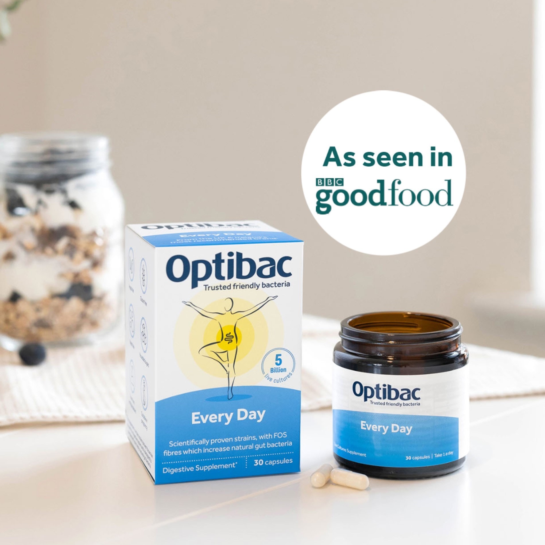 Optibac Every Day probiotic box and open bottle with capsules on a table, featuring a "As seen in BBC Good Food" label in the background.