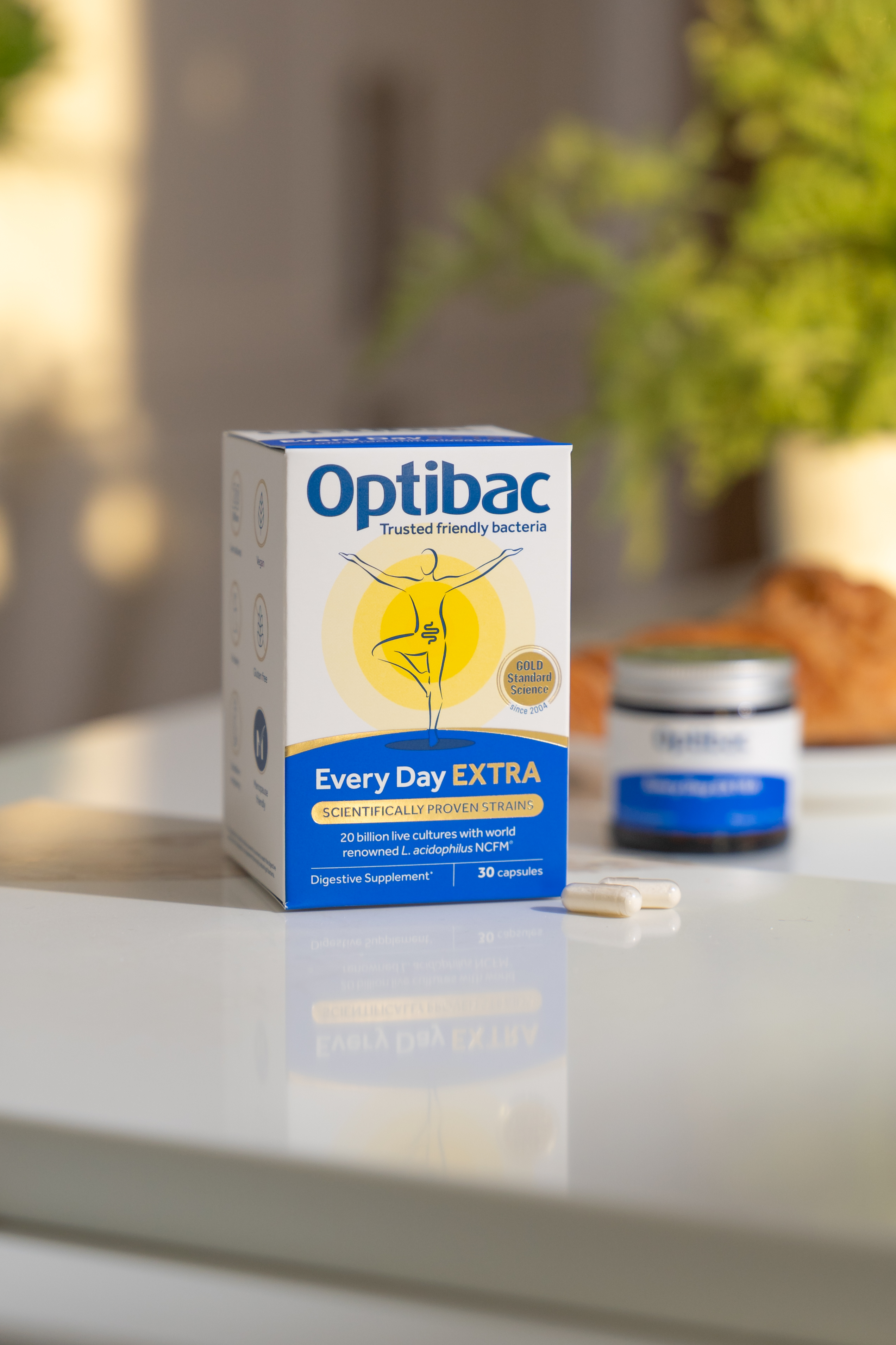 Optibac Every Day EXTRA probiotic box on a table with capsules, emphasizing digestive health and friendly bacteria.