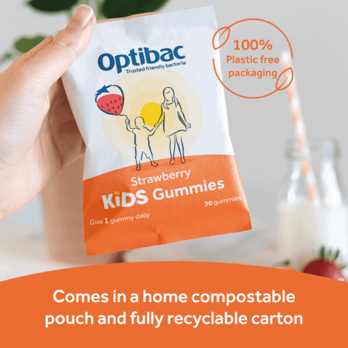 Hand holding a pouch of Optibac Strawberry Kids Gummies, with text highlighting compostable packaging and recyclable carton.