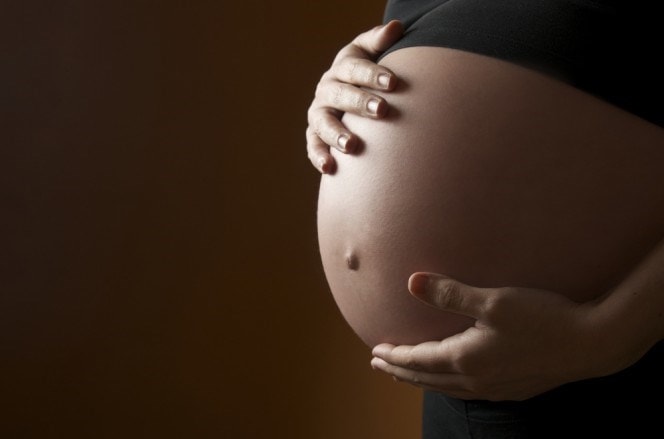 pregnant woman holding her tummy