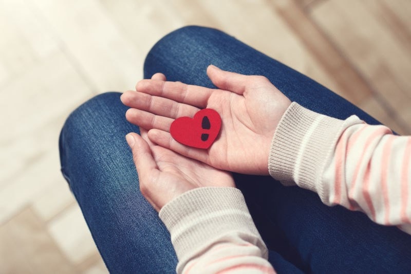 woman holding a heart shape in her hands