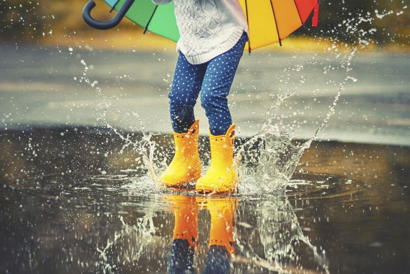 child splashing in puddles 