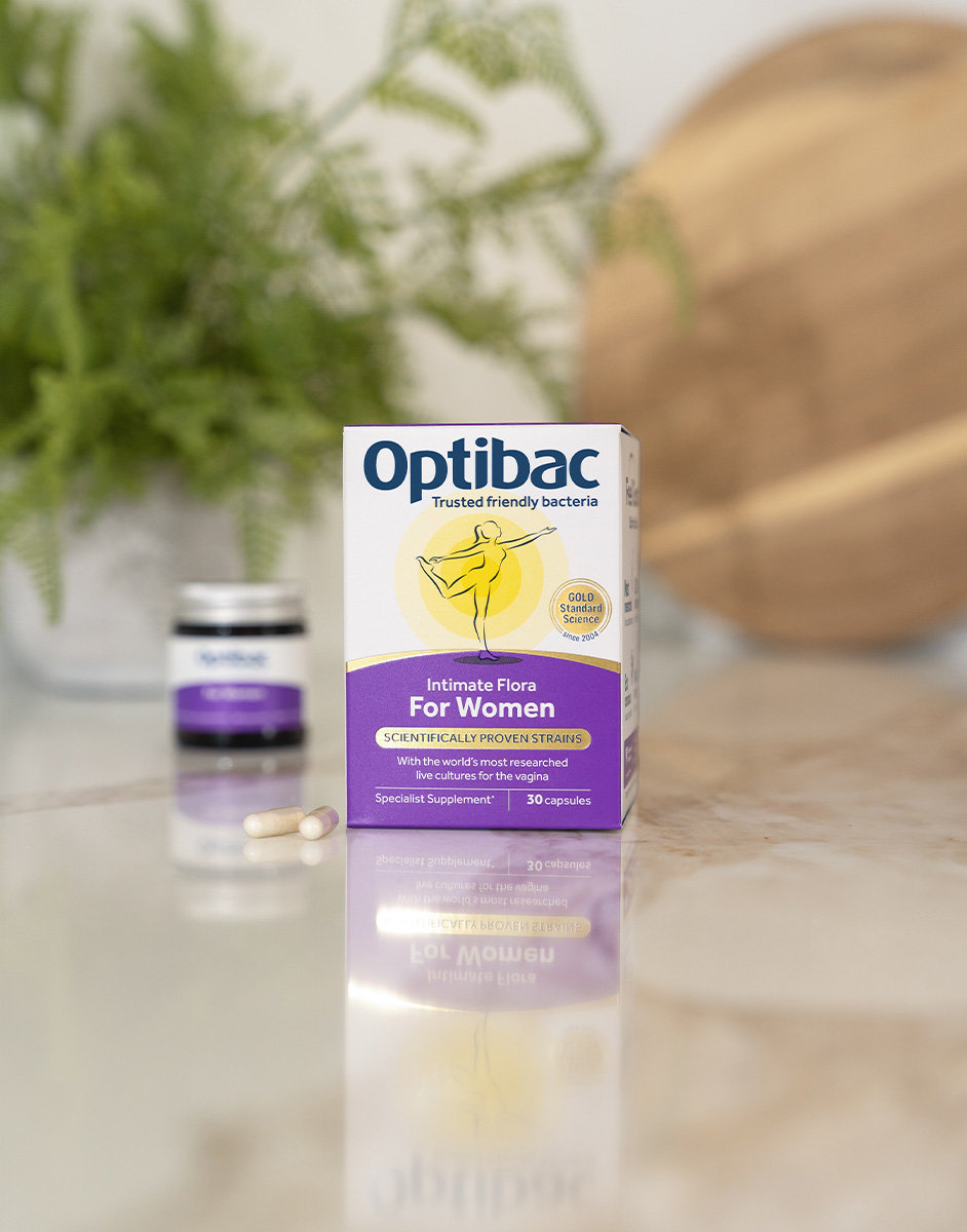 Box of Optibac Intimate Flora for Women on a marble surface, with a bottle and capsules in the background.
