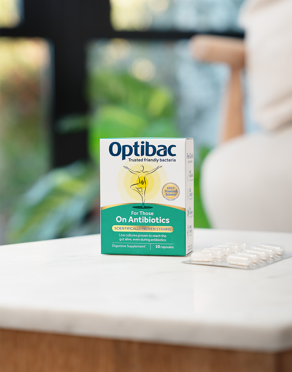 Box of Optibac probiotics for those on antibiotics, placed on a marble surface with a blister pack of capsules beside it.