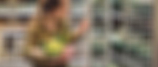 Woman holds vegetables in store