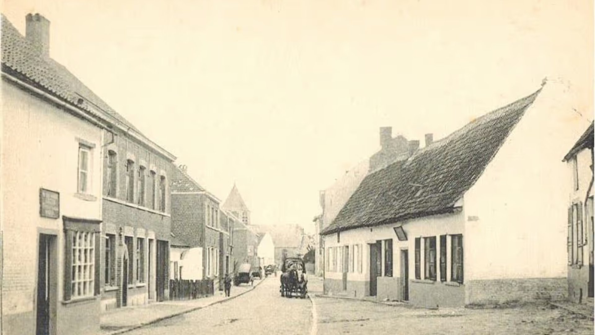Vintage street scene with cobblestone road, lined with old buildings. A horse-drawn carriage is in the distance.