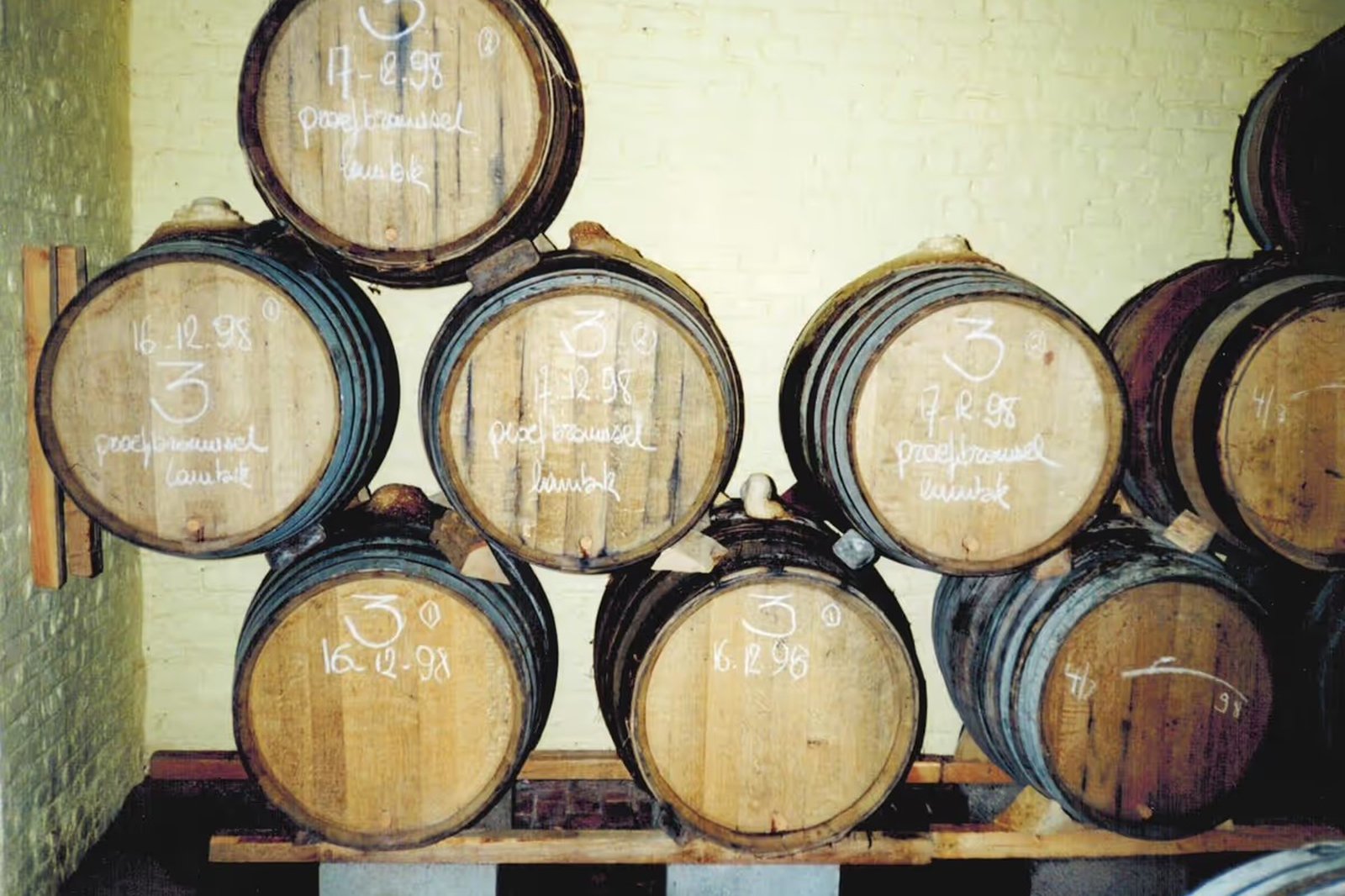 An archival shot of wooden barrels stacked two high in the old, low-ceilinged cellar.