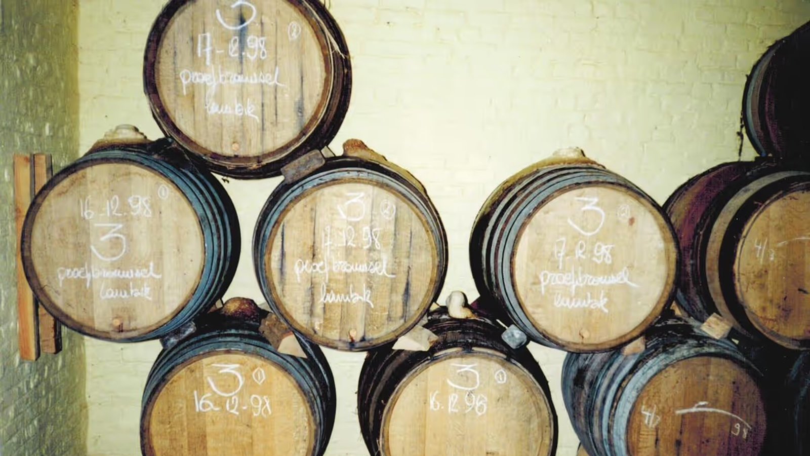 An archival shot of wooden barrels stacked two high in the old, low-ceilinged cellar.