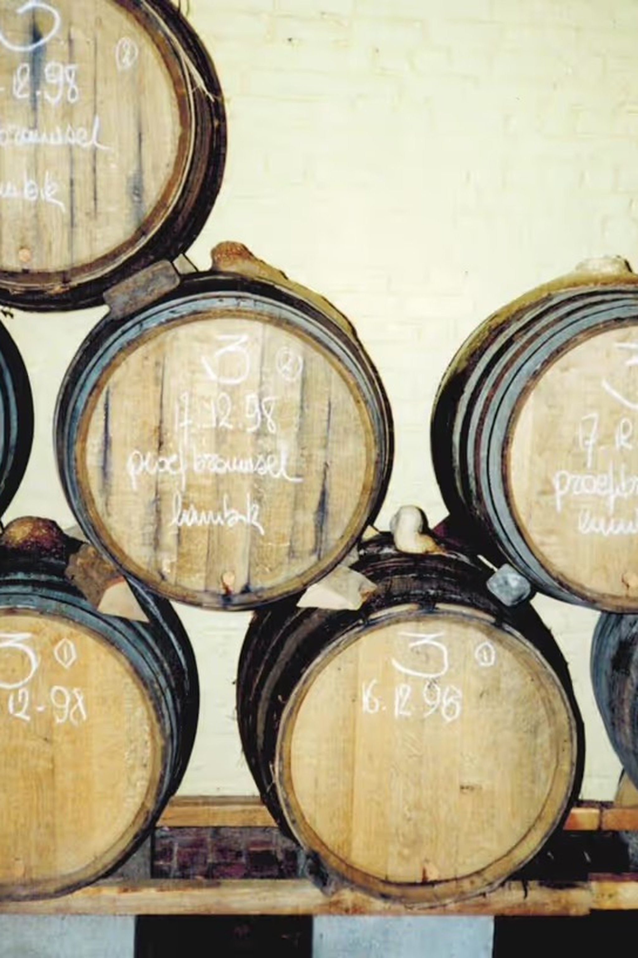 An archival shot of wooden barrels stacked two high in the old, low-ceilinged cellar.