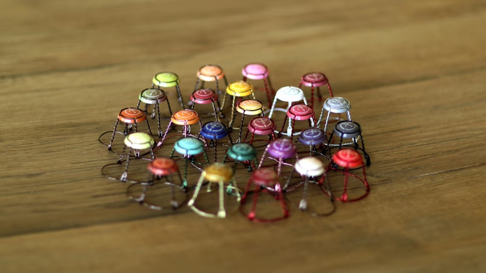A circular arrangement of colorful champagne wire cages on a wooden surface.