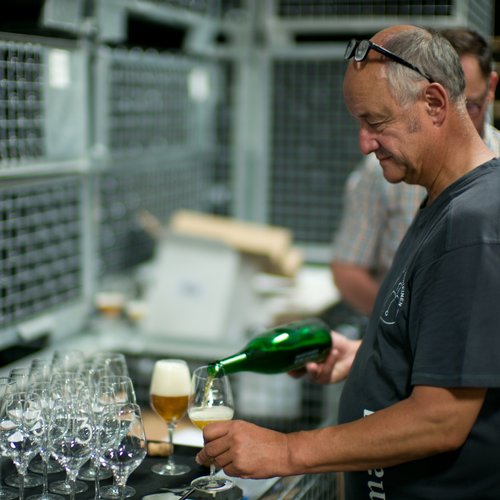 Armand pouring a  bottle of 3 Fonteinen Geuze into stemware glasses.