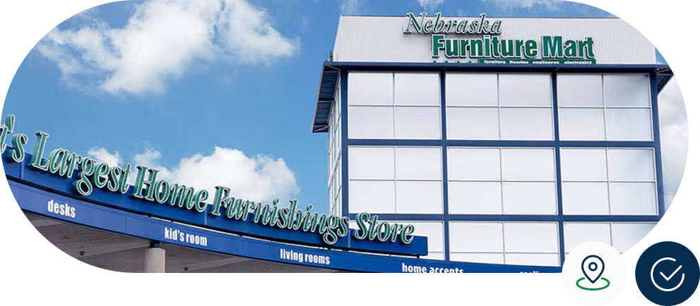 Exterior of Nebraska Furniture Mart building with large signage against a blue sky with clouds.