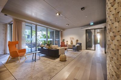 Moderne woonkamer zitmeubels, salontafel, vloerkleed en een glazen schuifdeur naar een terras.