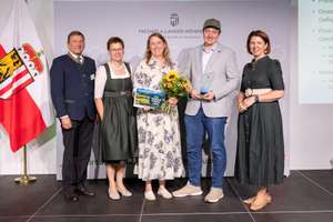 Gewinner der Kategorie Innovation stehen mit dem Preis und politischen Vertretern auf der Bühne.