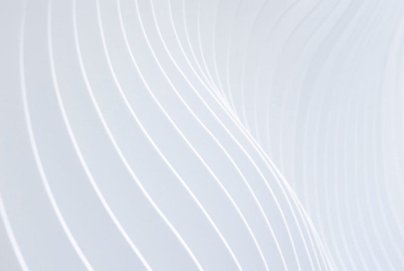 Watch Video: A close-up view of a white, curved architectural detail with repetitive wavy lines creating a sense of movement and texture.