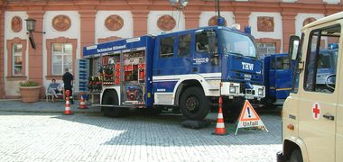 Ein blauer Einsatzwagen vom THW steht in der Innenstadt, ein Aufstellschild "Unfall" und Hütchen drumrum. Bei einer Übung in Bayreuth.