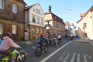 Viele Menschen fahren gemeinsam Fahrrad durch eine Straße in Bayreuth.