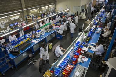 Arbeiter in einer Fabrikhalle für elektrische Fahrzeuge.